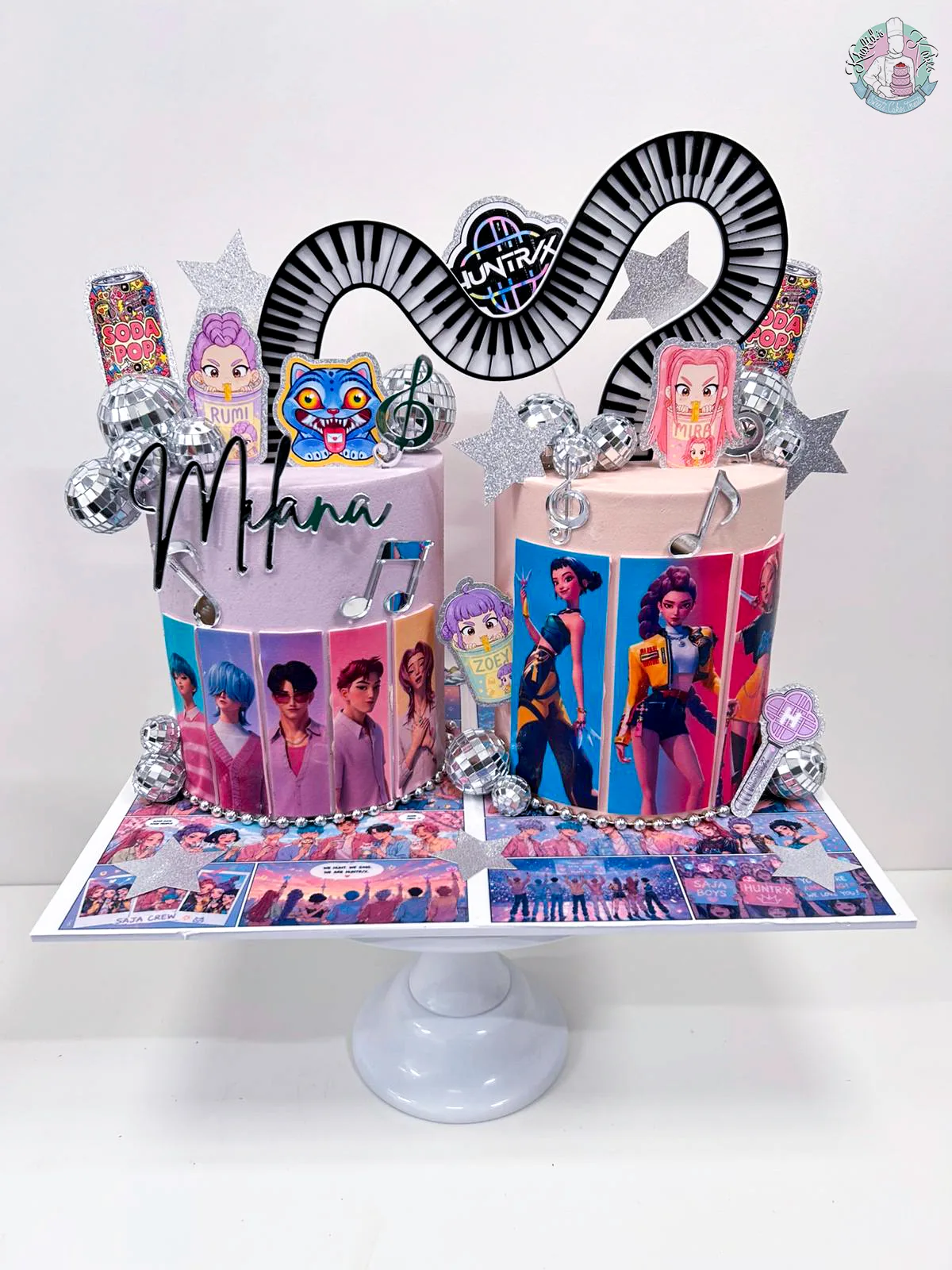 Joint Kpop Demon Hunters Cake Birmingham — black and pink cake with acrylic piano keys, comic character toppers and disco ball details, handmade by Khalid's Kakes