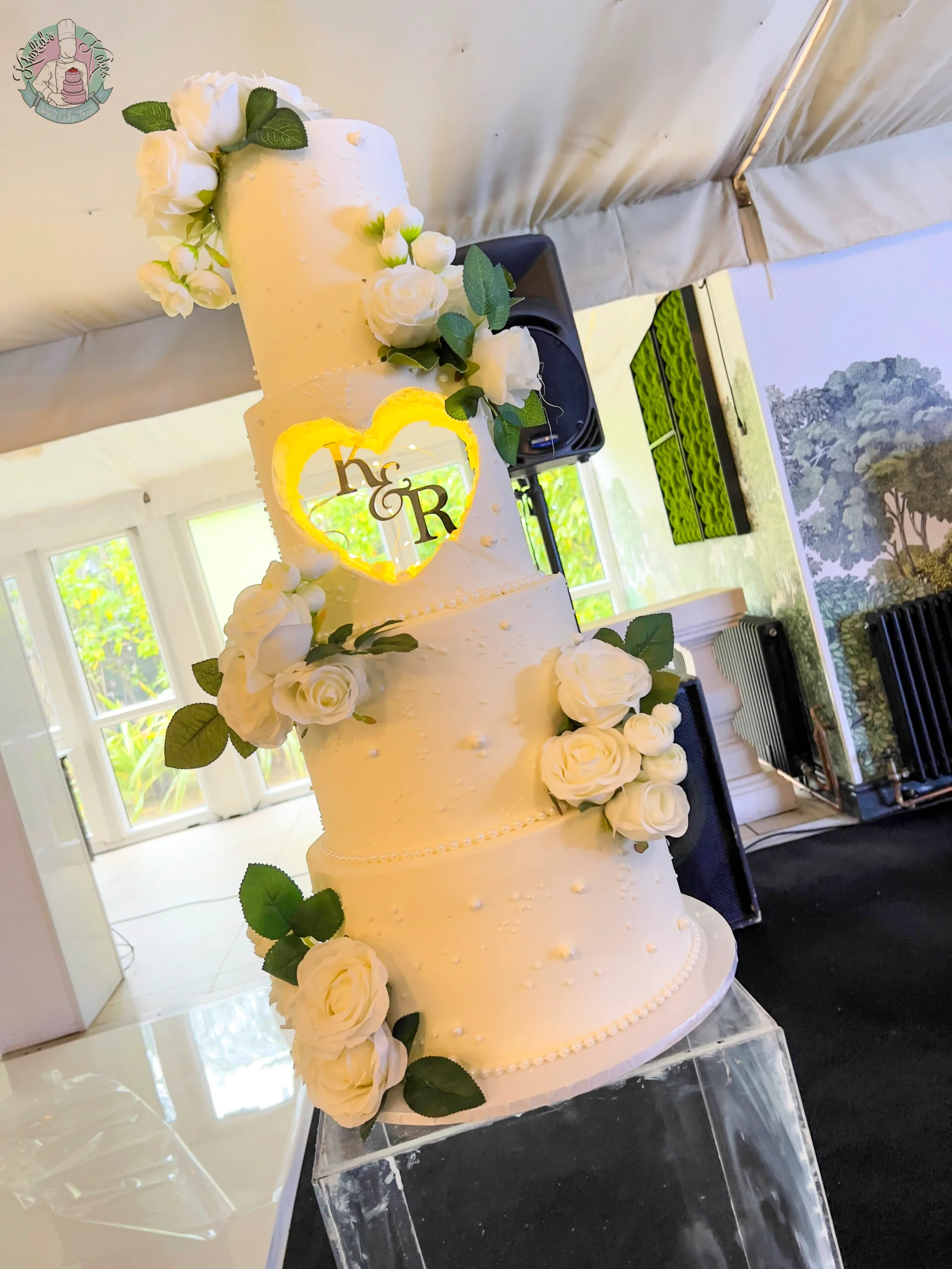 Hole Wedding Cake Birmingham — tiered cake with a distinctive centred hole tier lit with fairy lights and flower colour accents.