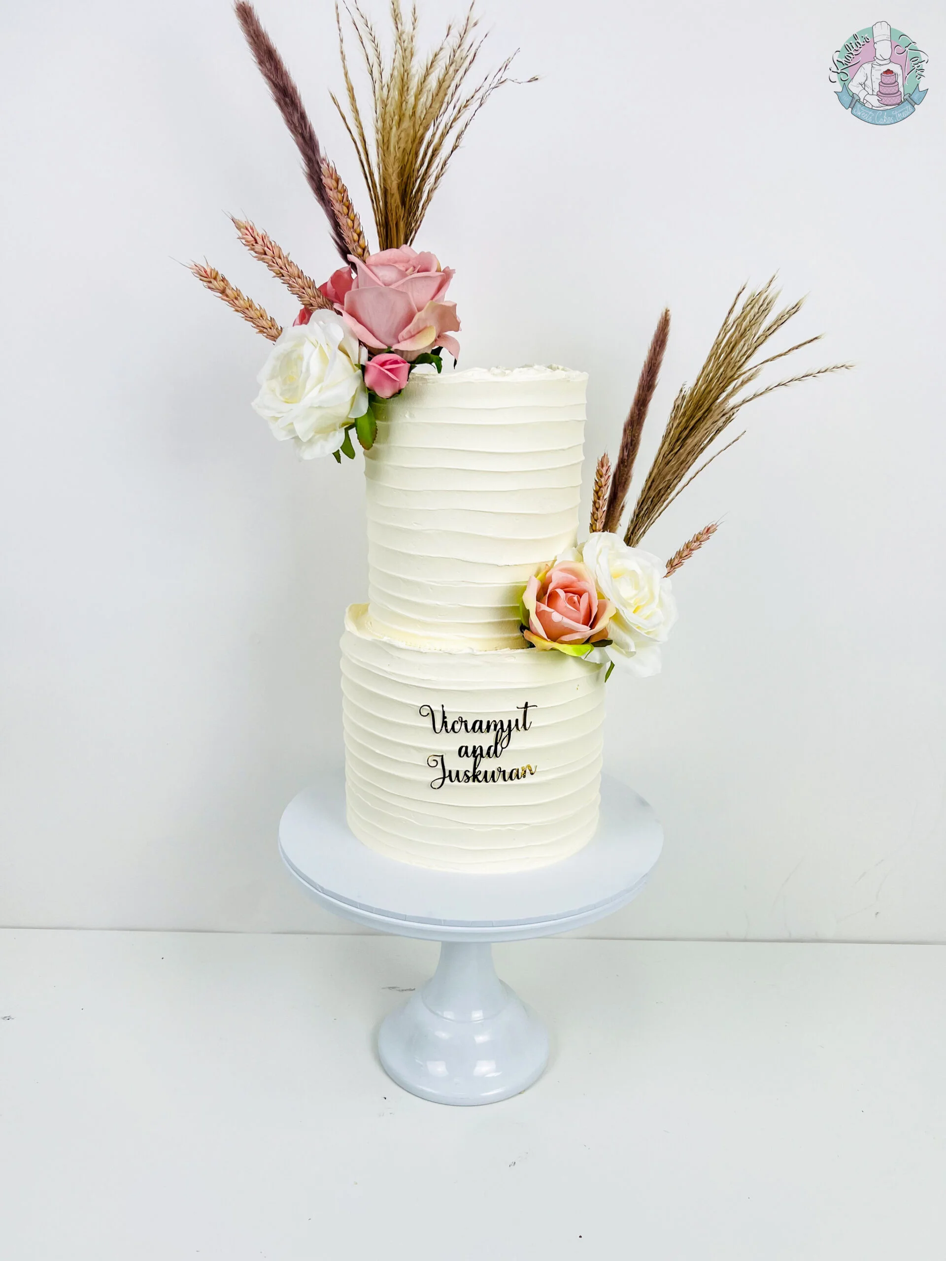 Pampas Wedding Cake Birmingham — tiered cake with soft pampas grass styling, a custom topper and flower colour accents.