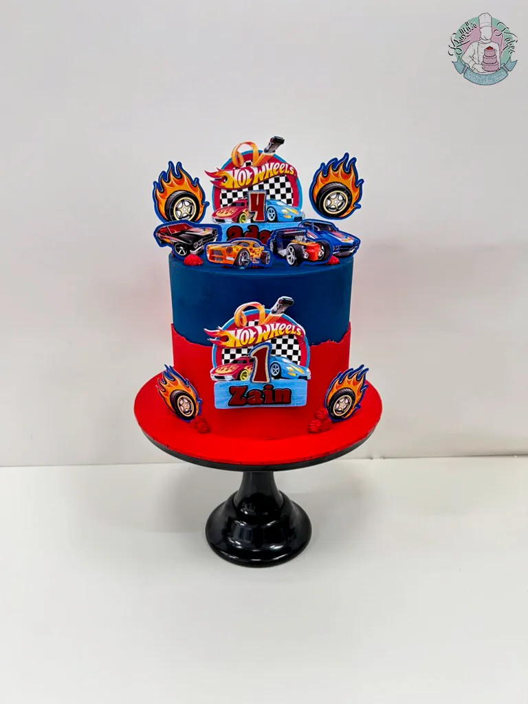 Hot Wheels Cake 2 Birmingham — bright red and blue racing cake with car toppers and checkered flag details, handmade by Khalid's Kakes