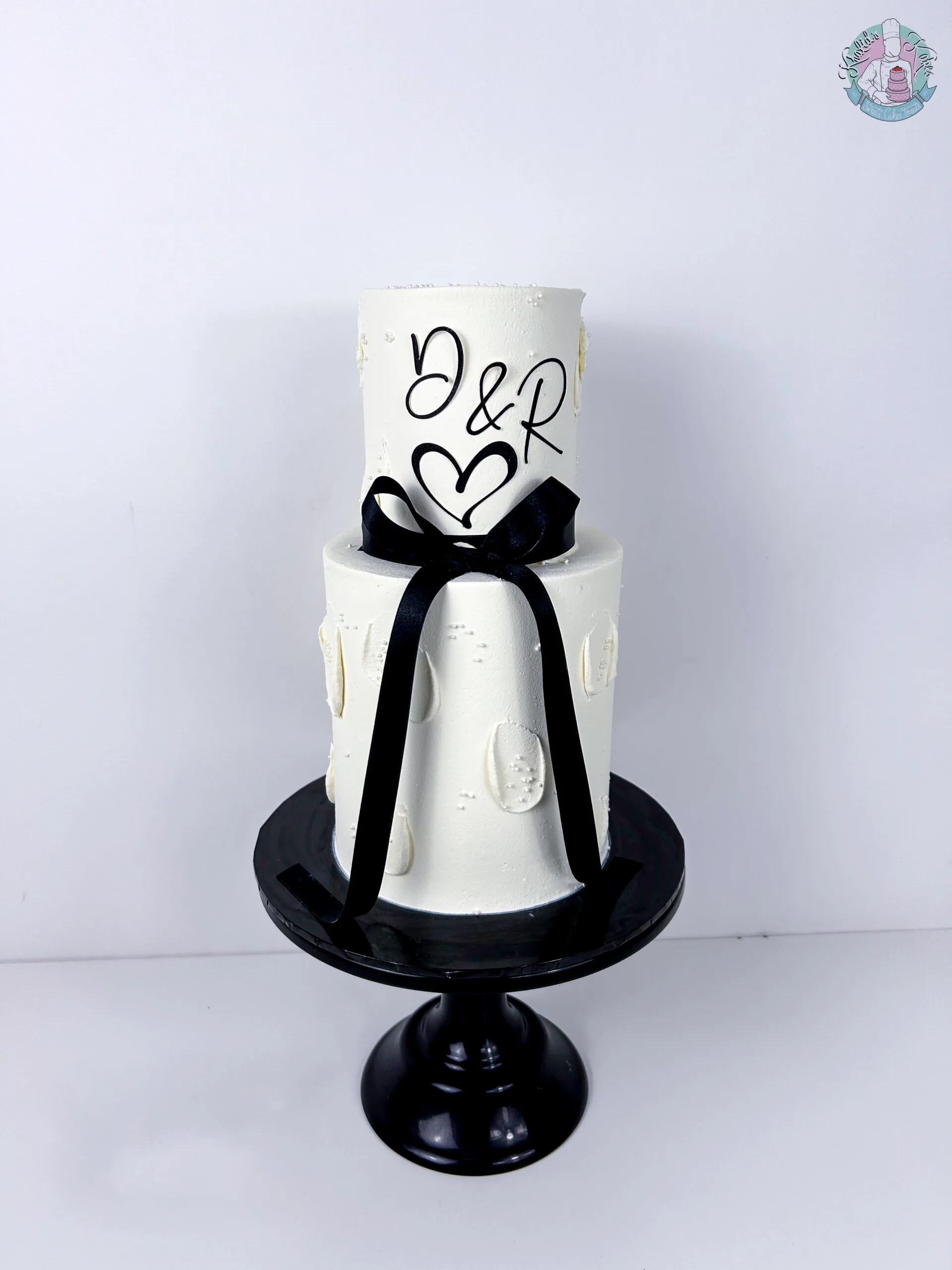 Mini Wedding Cake Birmingham — elegant two tier miniature cake finished with a large bow ribbon and flower colours.