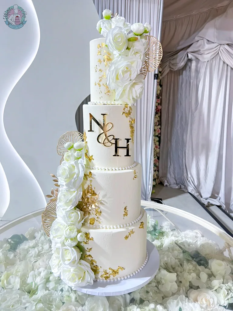 White and Gold Wedding Cake Birmingham — elegant tiered cake in white with gold detailing and a pearl ribbon finish.