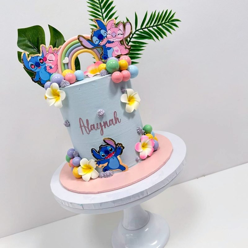 Lilo and Angel Cake Birmingham — pastel buttercream cake with Lilo and Stitch toppers and rainbow details, handmade by Khalid's Kakes