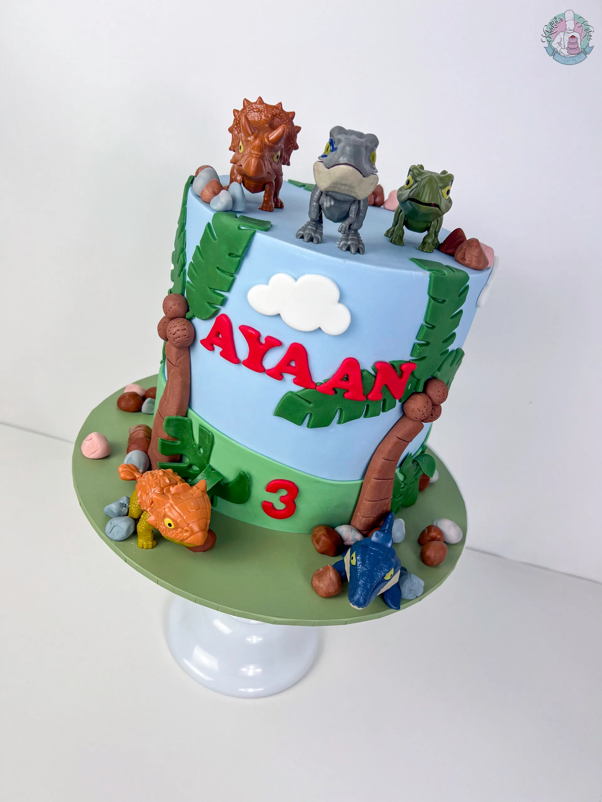 Dinosaur Cake Birmingham — children’s birthday cake with friendly dinosaurs and greenery.