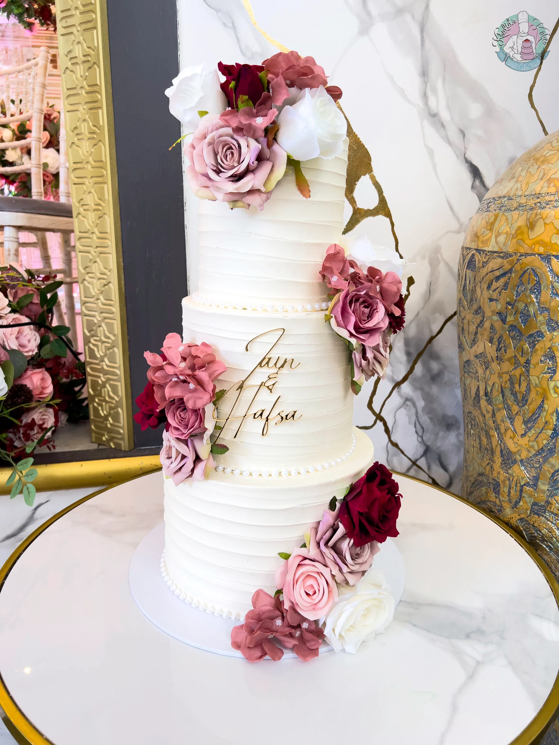 Bevelled Wedding Cake Birmingham — tiered cake with smooth sculpted bevelled edges and flower colour accents.