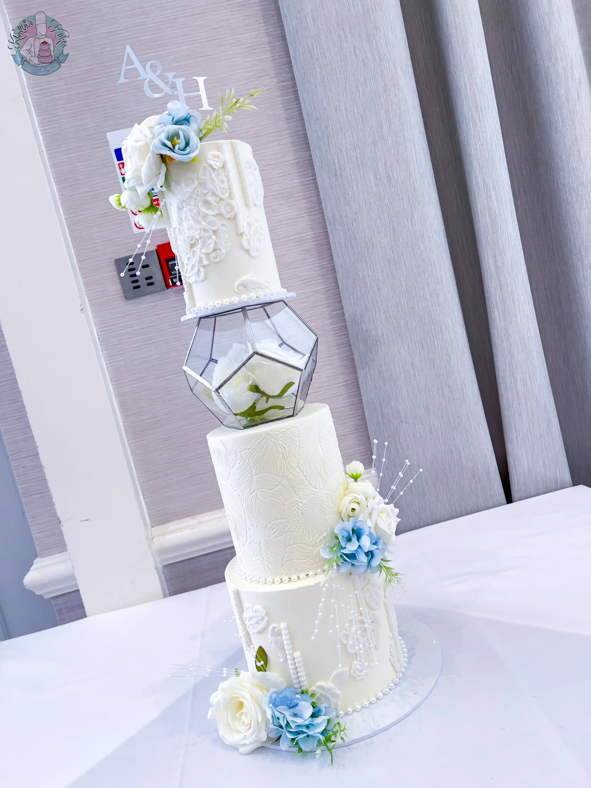 Stencil Hex Wedding Cake Birmingham — hexagonal tiered cake with fondant mould work, stencil detail, pearl sprays and a geometric spacer.