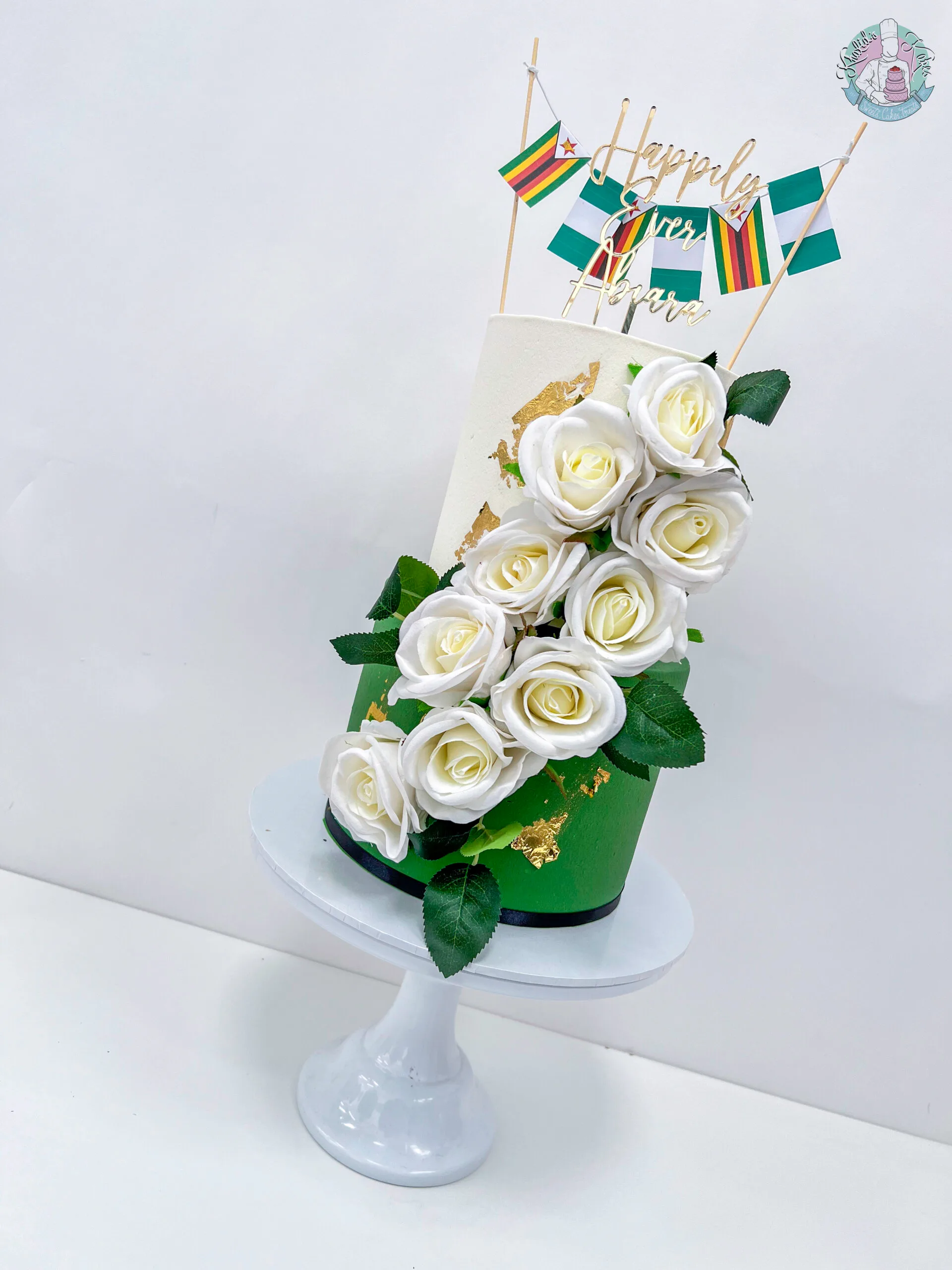 Roora Cake Birmingham — vibrant two or three tier celebration cake with metallic leaf accents and personalised detailing.